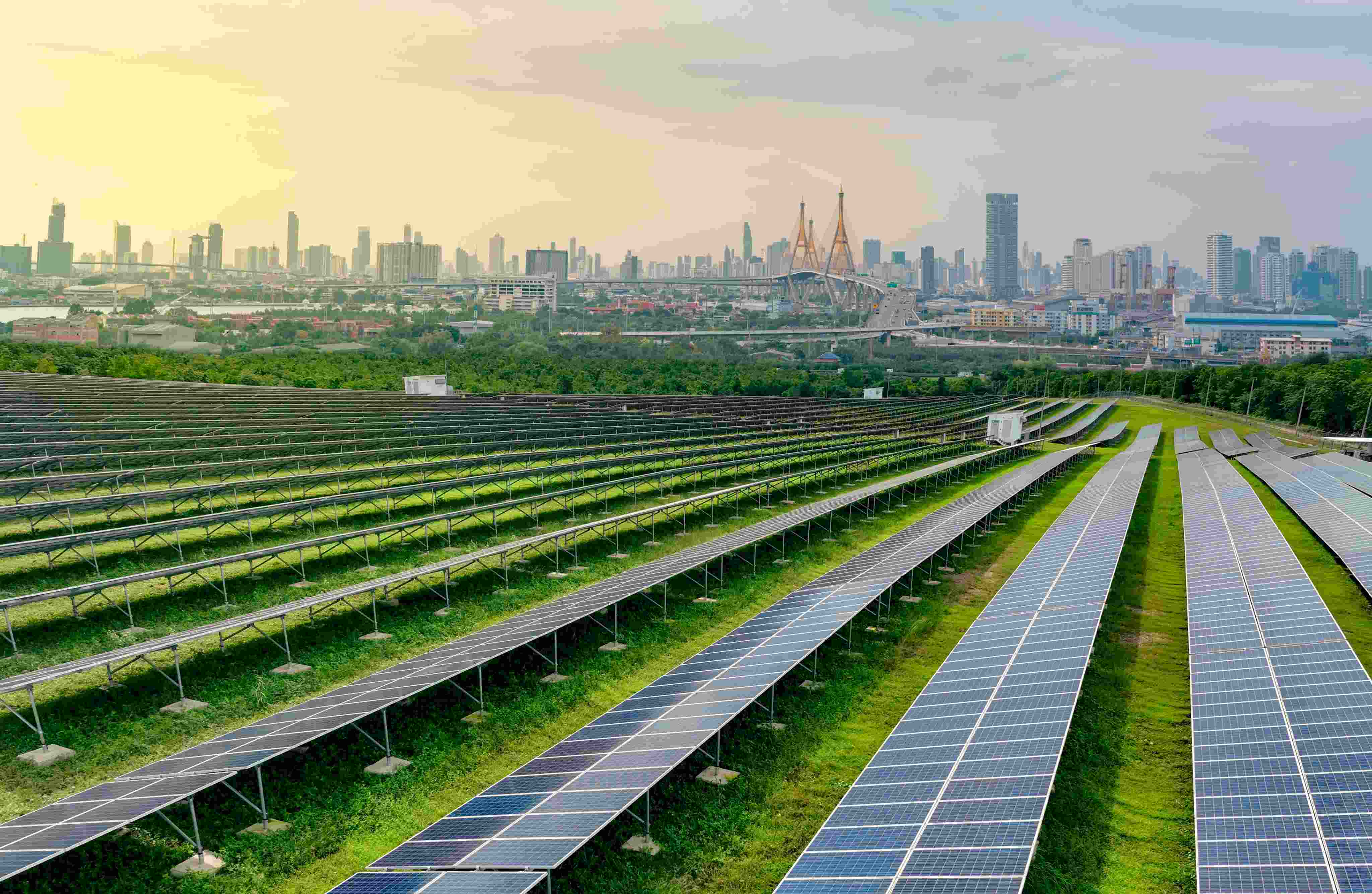 Vista de usina solar com cidade ao fundo, simbolizando o uso eficiente de recursos e
         a transição para fontes renováveis na economia circular industrial.