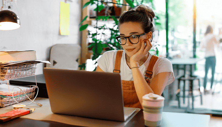 Moça de óculos mexendo em um computador